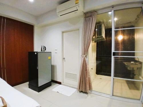 a room with a refrigerator and a window at Grand Lopburi in Lop Buri