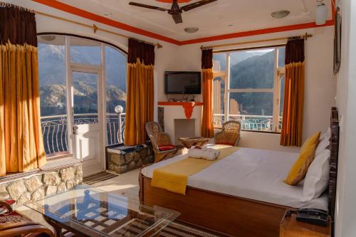a hotel room with a bed and a balcony at Hotel Victoriya Palace,Mcleod Ganj in McLeod Ganj