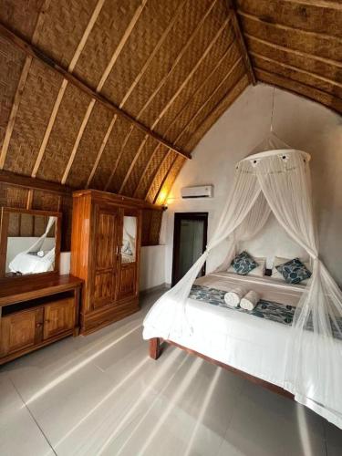 a bedroom with a bed with a mosquito net at Ocean View Sunset Heaven in Nusa Penida