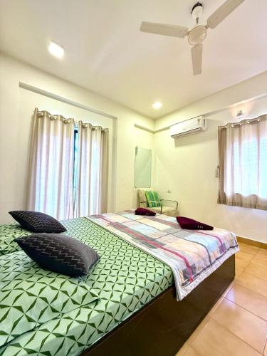 een slaapkamer met een bed en een plafondventilator bij yash villa in Lonavala