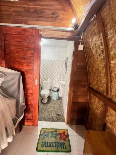 a bedroom with a bathroom with a toilet in it at Ocean View Sunset Heaven in Nusa Penida