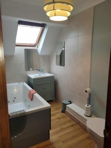 a bathroom with a tub and a sink and a toilet at Stay With Jack in Limerick