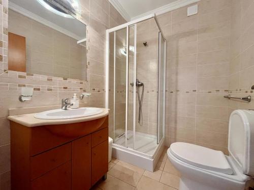 ein Badezimmer mit Dusche, Toilette und Waschbecken in der Unterkunft V4 moderno com Piscina - Burgau in Burgau