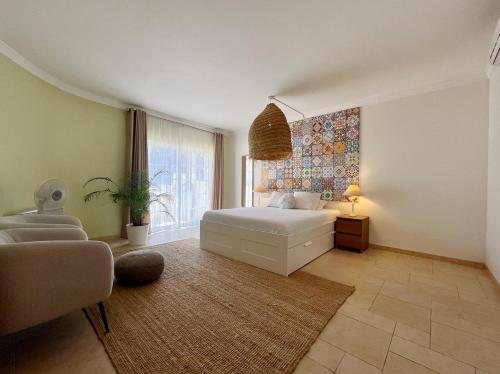 ein Schlafzimmer mit einem Bett und einem großen Fenster in der Unterkunft V4 moderno com Piscina - Burgau in Burgau