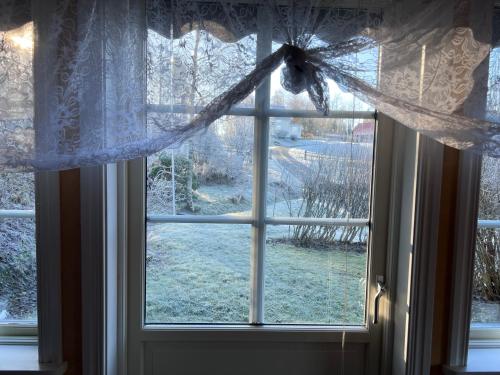 a window with a view of a snow covered yard at Sweet guest house with a view in Sävsjö