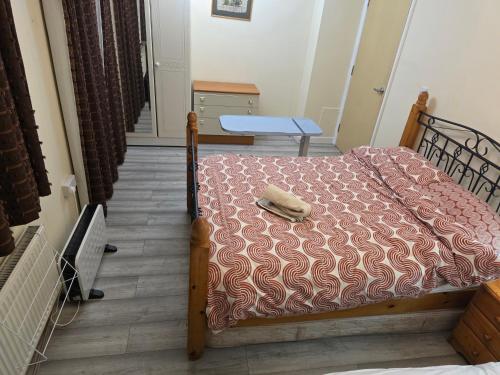a bedroom with a bed with a blanket and a table at Colchester, WIFI, free parking 1 in Hythe