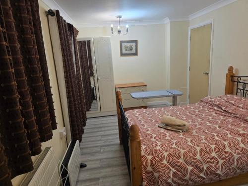 a bedroom with a bed and a table and a window at Colchester, WIFI, free parking 1 in Hythe