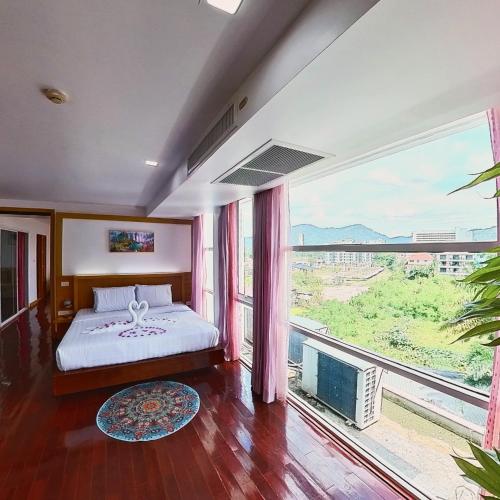 a bedroom with a bed and a large window at The Kris 2 Bedrooms 2 Bathrooms Apartment in Patong Beach