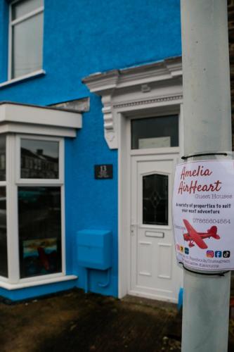 a blue building with a door with a sign in front at Amelia AirHeart in Swansea