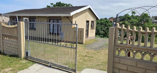a gate in front of a small house at Ingeyethu Guest House in Umlazi