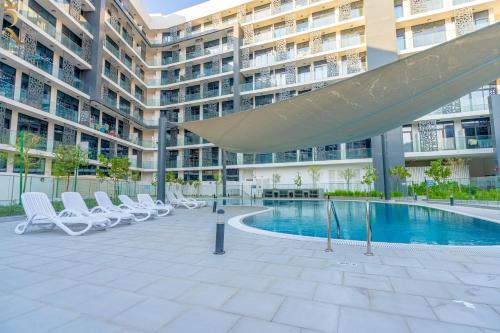 阿布扎比Bright 1BR with Balcony within 17 Min to Grand Prix的一座带游泳池和椅子的大型建筑