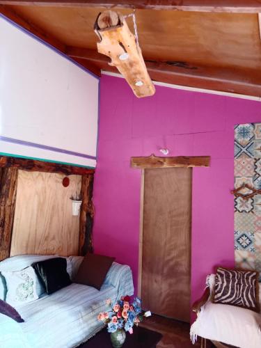 a room with a bed and a purple wall at Rústica Futaleufú in Futaleufú