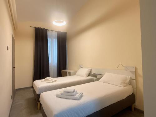 una stanza con due letti e una finestra di Hulin guesthouse a Roma