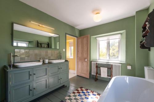 a bathroom with two sinks and a large mirror at Greengates Nature Filled Countryside Escape 