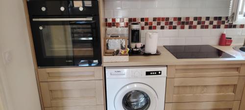 eine Küche mit einer Waschmaschine in der Unterkunft Maison game in Villeneuve-sous-Dammartin