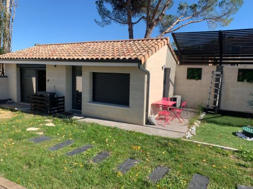 苔丝Apartment - Garden Studio - en extérieur de Bordeaux的一间小屋，里面有一张红桌子和一把红椅子