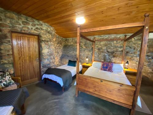 two beds in a room with a stone wall at Rondeberg Holiday Resort in Clanwilliam
