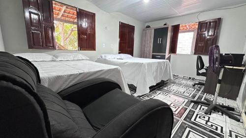 Zimmer mit 2 Betten, einem Sofa und einem TV in der Unterkunft Recanto da Rosa in Santarém