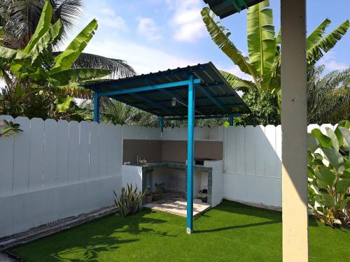 Una pérgola azul en un patio junto a una valla. en Echah's Homestay-mslim only, en Jeram