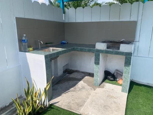 um balcão de cozinha com um lavatório num quintal em Echah's Homestay-mslim only em Jeram