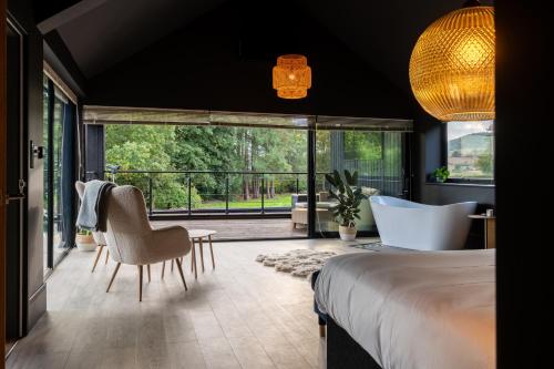 a bedroom with a bed and a large window at Nor67 - Witley Park House in Little Witley