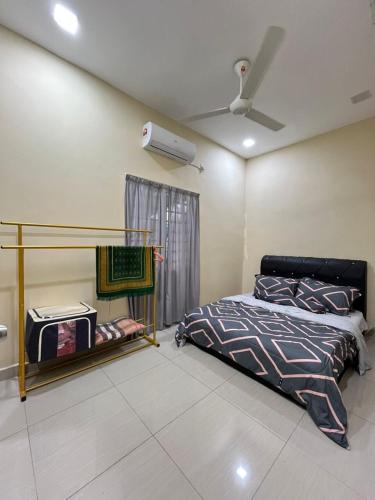 a bedroom with a bed and a ceiling fan at Echah's Homestay-mslim only in Jeram