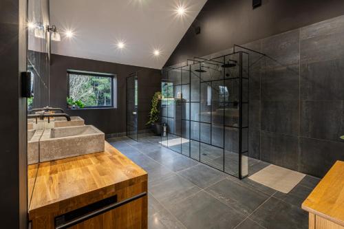 a bathroom with a glass shower and a sink at Nor67 - Witley Park House in Little Witley