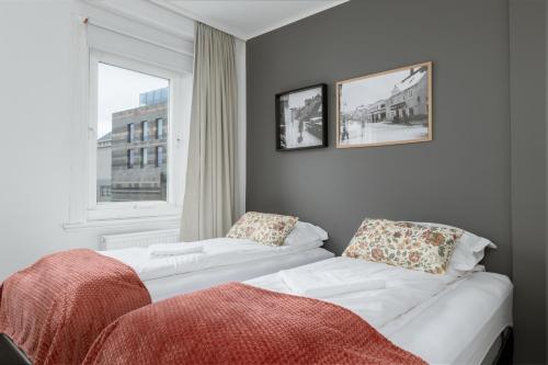 two white beds in a room with a window at Old Town Reykjavik in Reykjavík