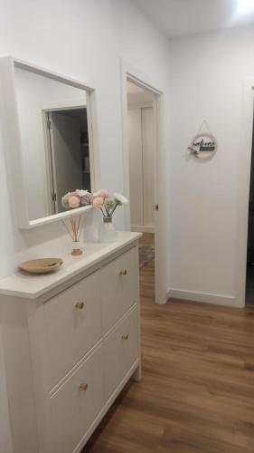a bathroom with a white dresser with a mirror at Nordés in Vilagarcia de Arousa