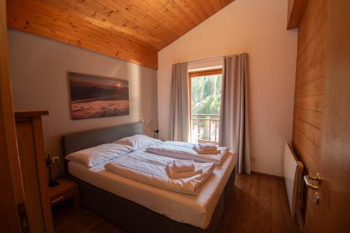 a small bedroom with a bed with a window at Chalet Gondelblick in Zell am See