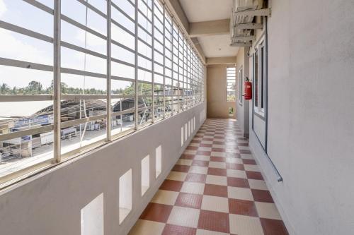 a hallway with a checkered floor and windows at Collection O Preethi Boarding & Lodging in Kammasandra