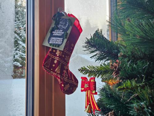 ein Weihnachtsstrumpf, der an einem Weihnachtsbaum hängt in der Unterkunft 2-bedroom, fenced yard, sauna, 10 min to Pärnu in Pärnu