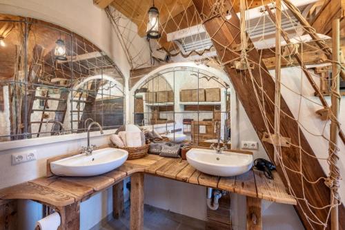 ein Badezimmer mit zwei Waschbecken und einem großen Spiegel in der Unterkunft Kaiserhaus Holiday Apartments in Ebbs