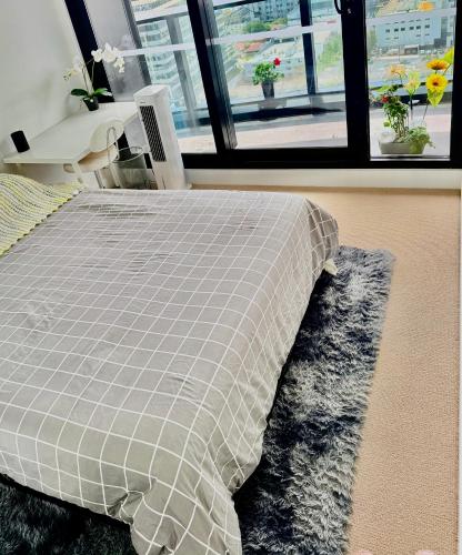 a bedroom with a bed and a table and a window at Private Room and bathroom in Shared Apartment with Host in Box Hill
