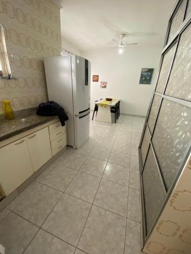 eine Küche mit einem Kühlschrank und einem Tisch darin in der Unterkunft Casa de praia peruibe in Peruíbe
