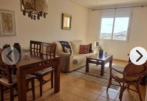 a living room with a table and a couch at Luminoso Terrazas Piscinas Parking in Vera