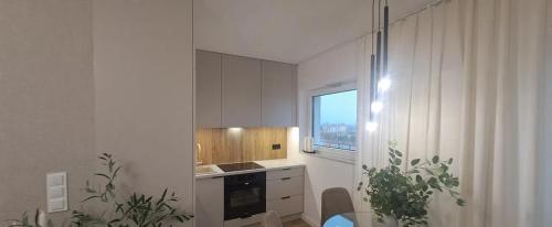 a kitchen with white cabinets and a window at Studio Magnolia Suite in Poznań