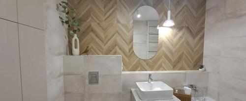 a bathroom with a sink and a mirror at Studio Magnolia Suite in Poznań