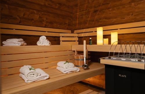 un sauna avec des serviettes sur des étagères à côté d'un lavabo dans l'établissement KitzSki Luxury Apartment ski-in ski-out accommodation, à Mittersill