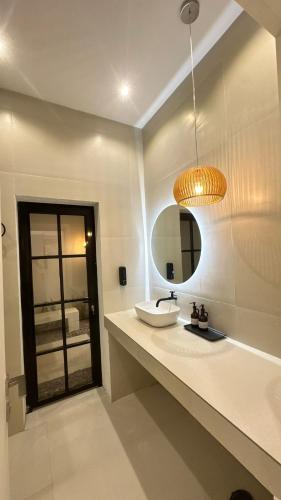 a bathroom with a sink and a mirror at SUN Chalet in Al Ghabbī