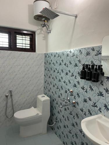 a bathroom with a toilet and a sink at Temple Courtyard in Chengannūr