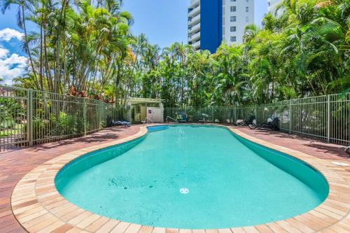 a swimming pool in a resort with trees at The Meriton Apartments on Main Beach in Gold Coast