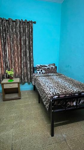 een slaapkamer met een bed, een tafel en een gordijn bij Cliff Hostel in Amman