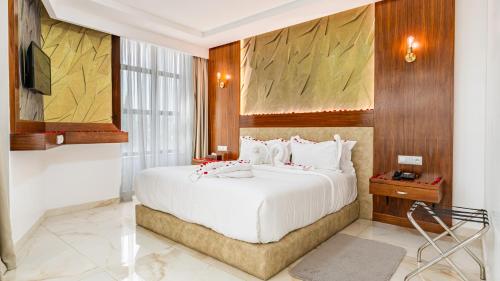 a bedroom with a large white bed and a television at MIRANDA HOTEL - Tanger in Tangier