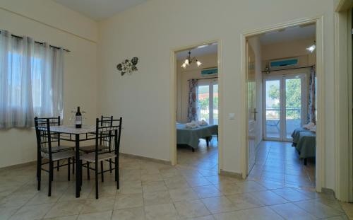 ein Esszimmer mit einem Tisch und Stühlen in einem Raum in der Unterkunft Kamarina Apartments in Peroulades