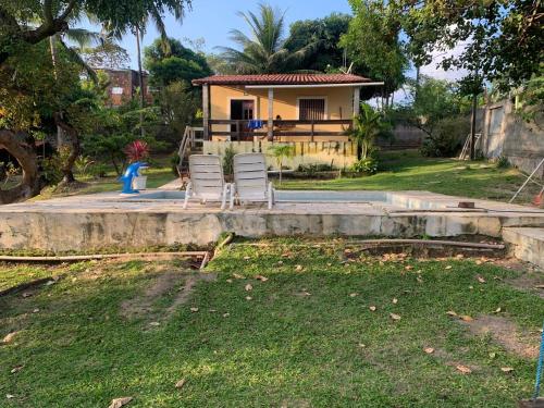 two chairs sitting in front of a house at Casa de praia Itamaracá in Itamaracá