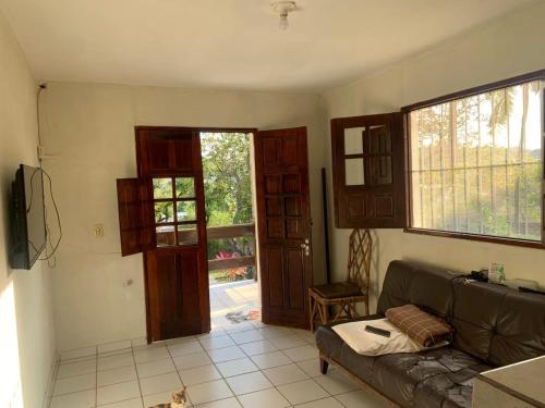 a living room with a couch and an open door at Casa de praia Itamaracá in Itamaracá