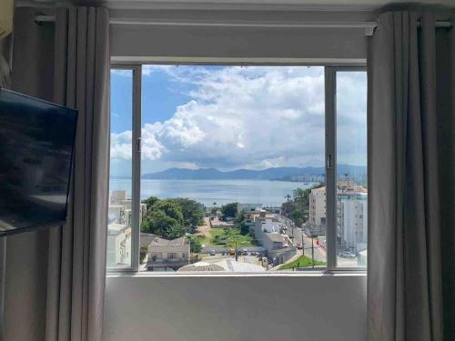 a large window with a view of the water at Loft vista incrível beira mar continental in Florianópolis