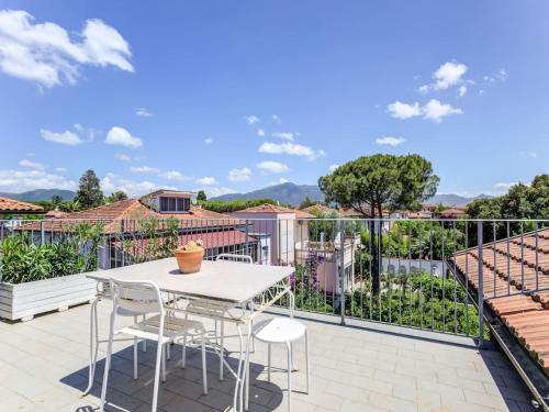 a patio with a white table and chairs on a balcony at Pisa Getaway by the Tower in Pisa