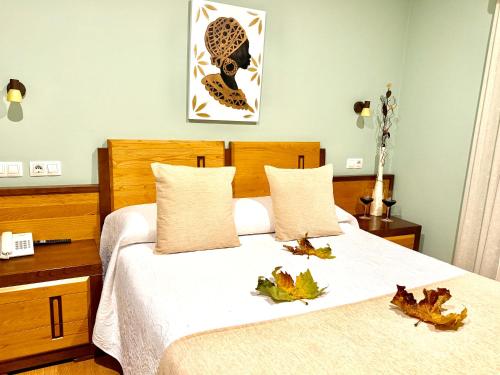 a bedroom with a bed with leaves on it at Hotel Spa Galatea in Burela de Cabo